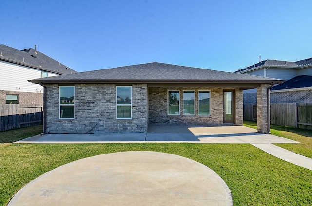 rear view of property with a lawn and a patio area