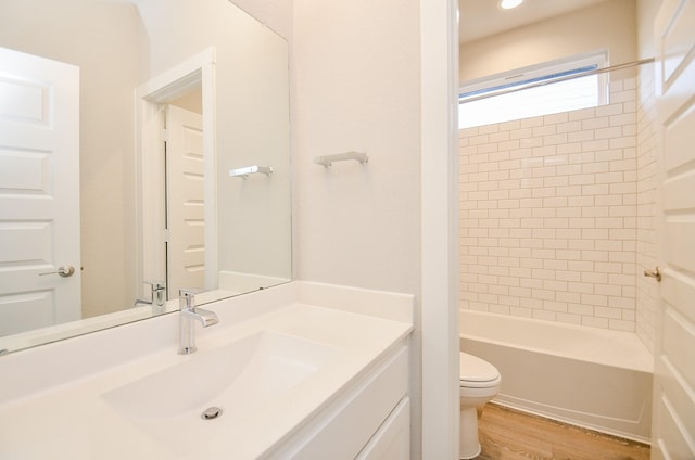 full bathroom with toilet, vanity, tiled shower / bath combo, and hardwood / wood-style flooring