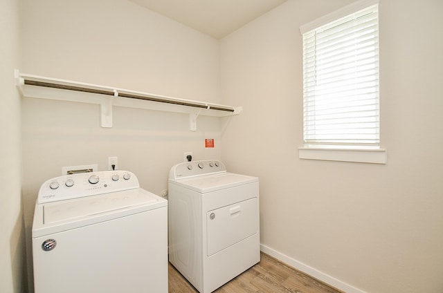 washroom with independent washer and dryer and light hardwood / wood-style flooring