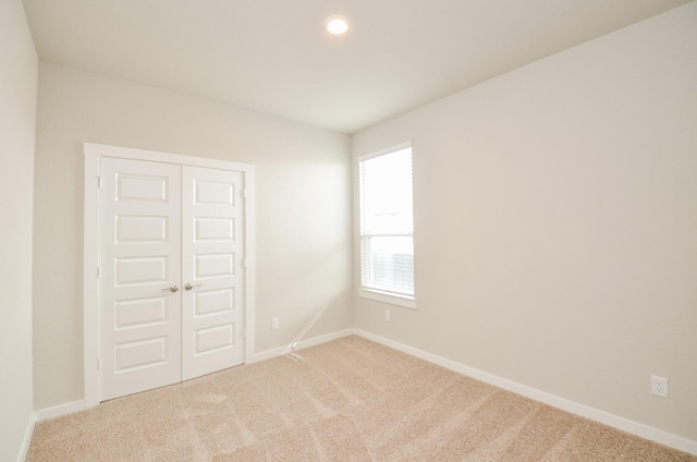 unfurnished room featuring light carpet