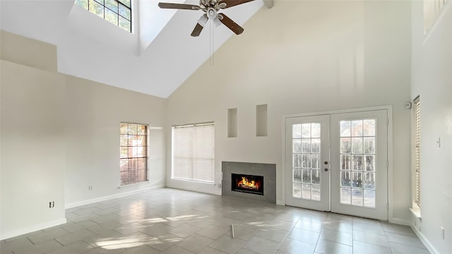 unfurnished living room with a wealth of natural light, french doors, high vaulted ceiling, and ceiling fan