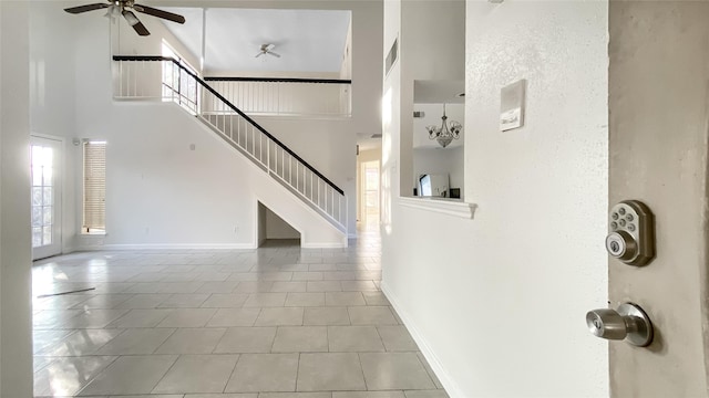 interior space featuring a towering ceiling, tile patterned floors, and ceiling fan