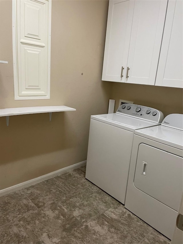 laundry area with washing machine and clothes dryer and cabinets