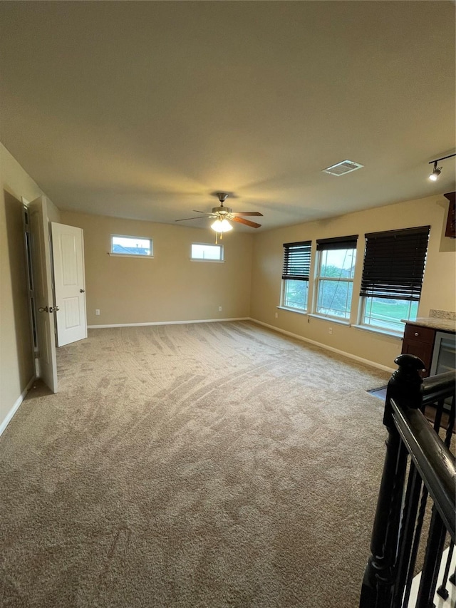 unfurnished living room featuring ceiling fan and carpet