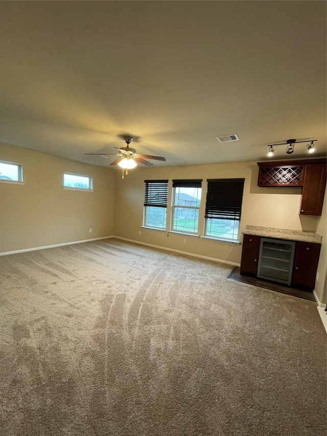 interior space featuring carpet floors, track lighting, wine cooler, and ceiling fan