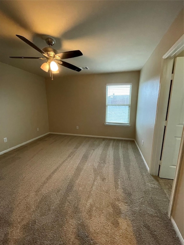 carpeted empty room featuring ceiling fan