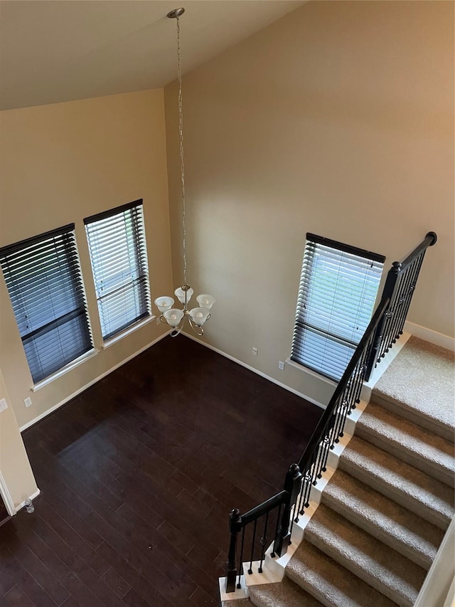 interior space with dark hardwood / wood-style flooring, high vaulted ceiling, and a notable chandelier