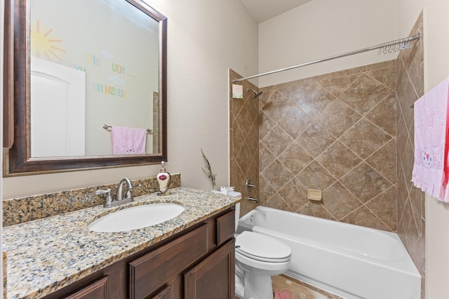 full bathroom with vanity, tiled shower / bath combo, and toilet