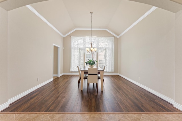 unfurnished dining area with dark hardwood / wood-style flooring, vaulted ceiling, an inviting chandelier, and ornamental molding