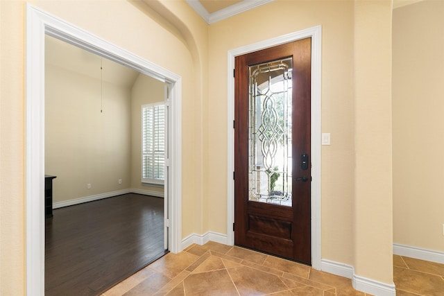 tiled foyer entrance featuring crown molding