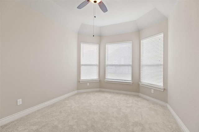 carpeted spare room with ceiling fan and vaulted ceiling