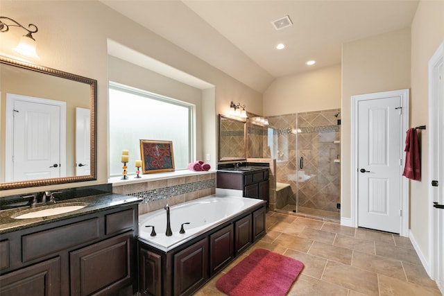 bathroom with tile patterned floors, vanity, separate shower and tub, and vaulted ceiling