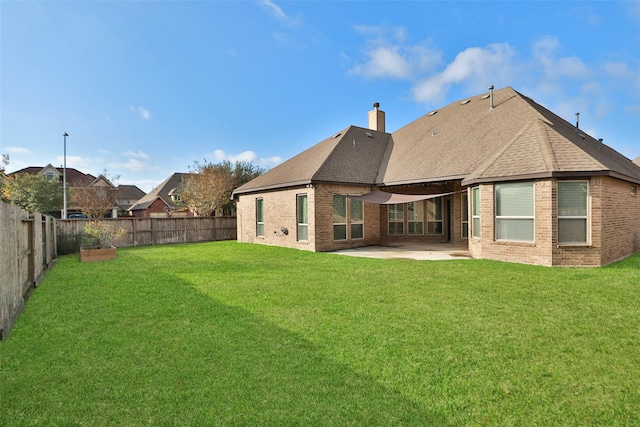 rear view of house with a lawn and a patio area