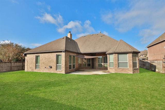 back of house with a patio area and a lawn