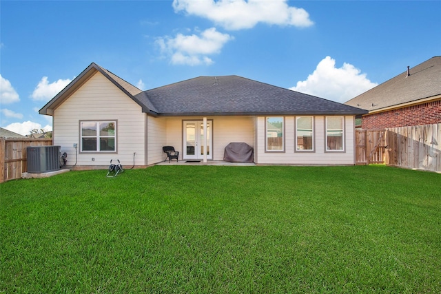 rear view of house with french doors, cooling unit, a patio area, and a lawn