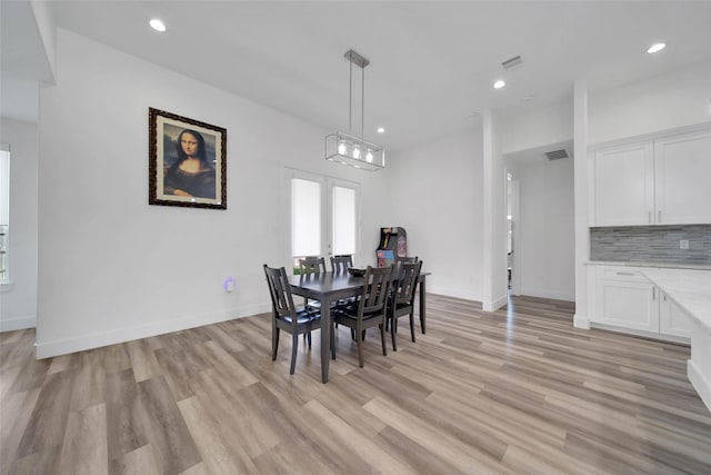 dining room featuring french doors and light hardwood / wood-style flooring