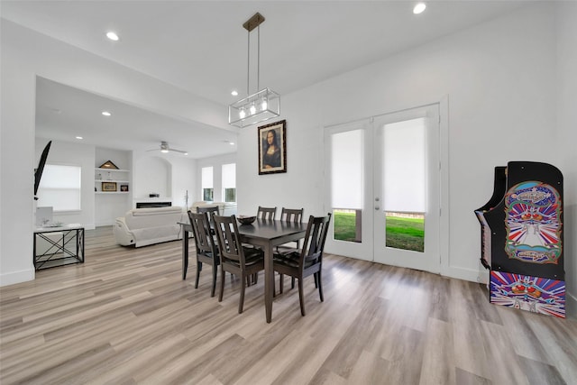 dining space featuring ceiling fan, built in features, french doors, and light hardwood / wood-style flooring