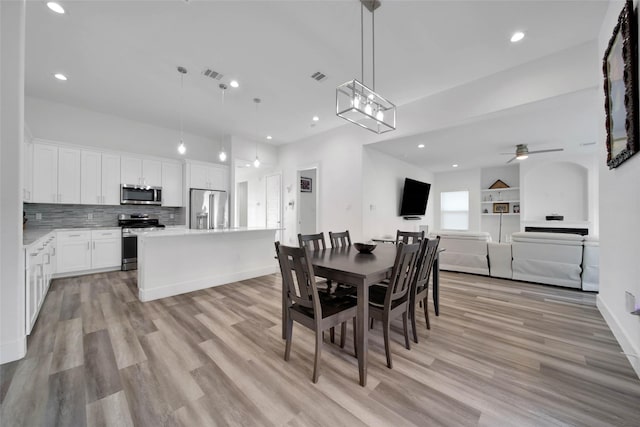 dining area with ceiling fan and light hardwood / wood-style flooring