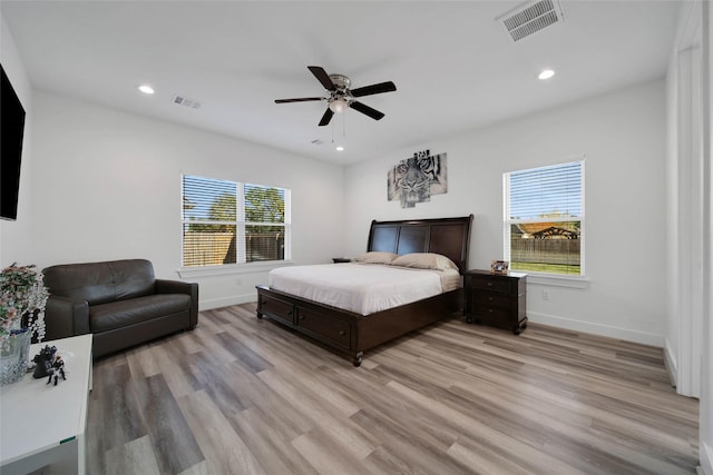 bedroom featuring light hardwood / wood-style flooring, multiple windows, and ceiling fan