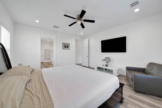 bedroom featuring connected bathroom, ceiling fan, and light wood-type flooring