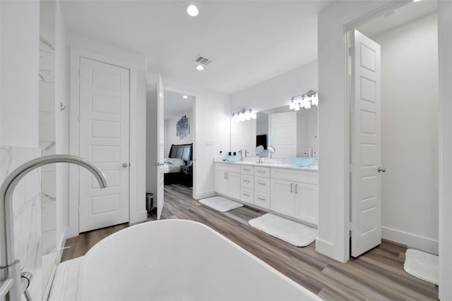 bathroom featuring vanity, a bath, and hardwood / wood-style flooring