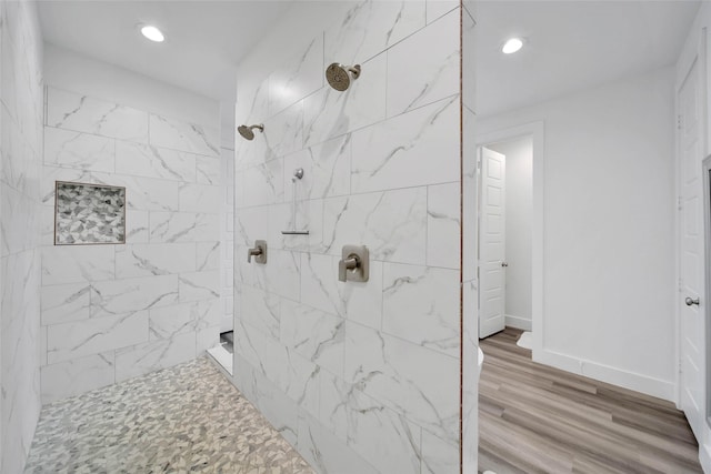 bathroom featuring a tile shower and hardwood / wood-style flooring