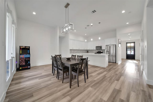 dining space with french doors and light wood-type flooring