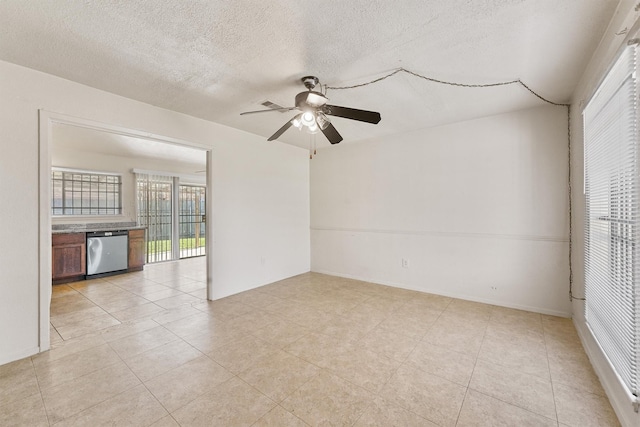 tiled empty room with ceiling fan and a textured ceiling