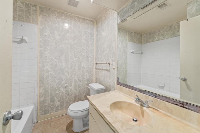 full bathroom featuring vanity, tile patterned floors, tiled shower / bath combo, toilet, and tile walls