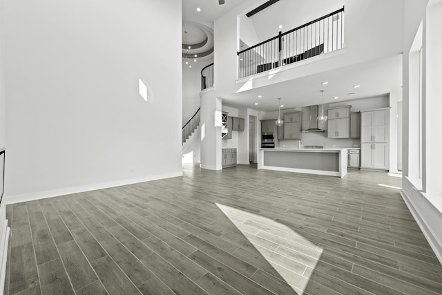 unfurnished living room with a high ceiling and dark hardwood / wood-style flooring