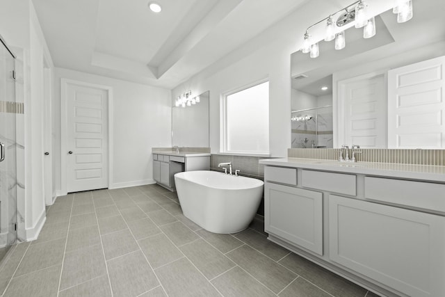 bathroom featuring shower with separate bathtub, vanity, a raised ceiling, and tile patterned floors