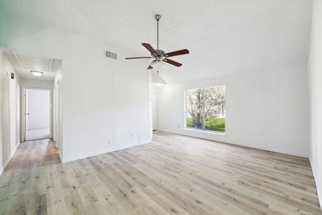 empty room with ceiling fan, light wood-type flooring, and vaulted ceiling