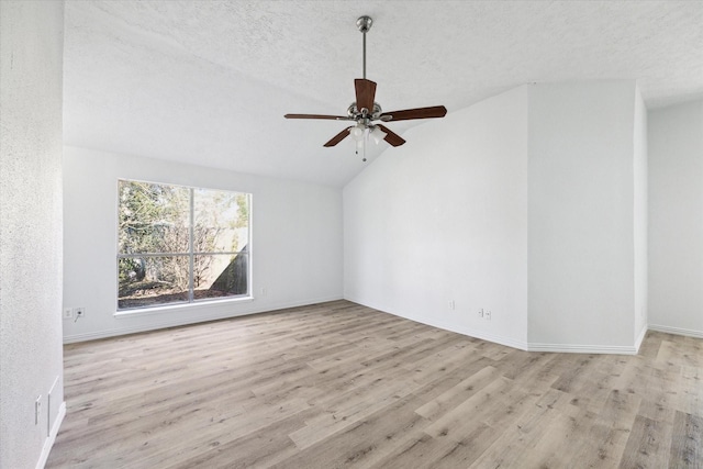 unfurnished room featuring a textured ceiling, ceiling fan, light hardwood / wood-style floors, and vaulted ceiling