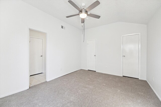 unfurnished bedroom featuring light colored carpet, ceiling fan, and lofted ceiling