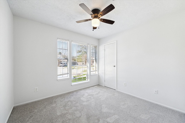 empty room featuring light carpet, ceiling fan, and a textured ceiling