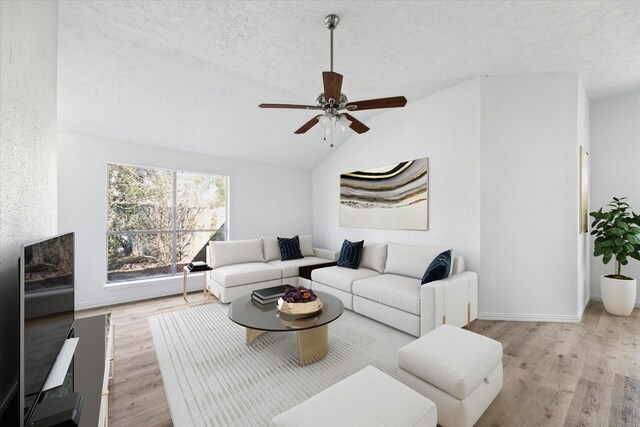 living room featuring light hardwood / wood-style floors, a textured ceiling, and vaulted ceiling