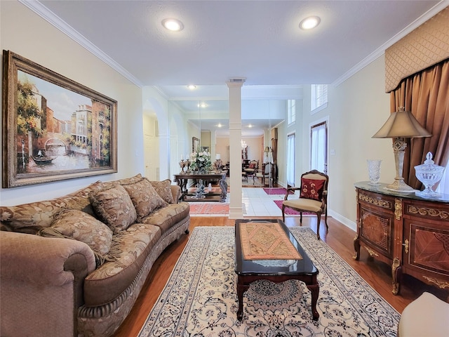 living room featuring hardwood / wood-style flooring, ornate columns, and ornamental molding