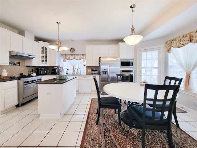 kitchen with white cabinetry, hanging light fixtures, a kitchen island, and stainless steel appliances