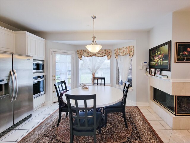 dining space with a fireplace and light tile patterned floors