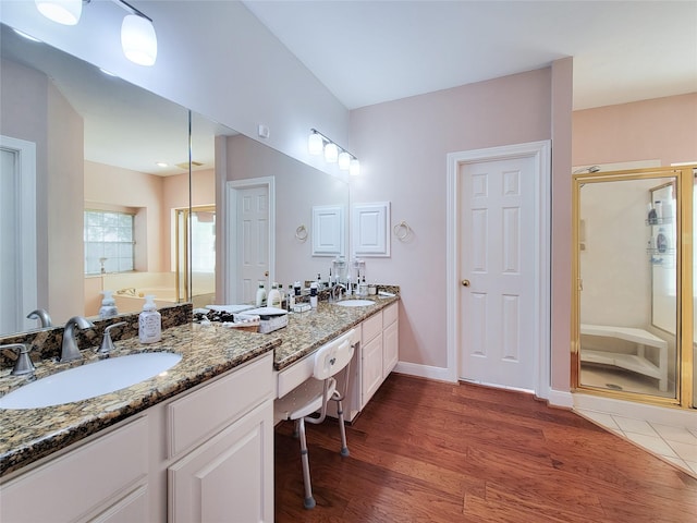 bathroom featuring wood-type flooring, vanity, and a shower with door