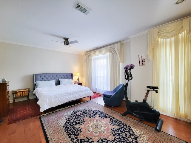 bedroom with hardwood / wood-style floors, ceiling fan, and ornamental molding