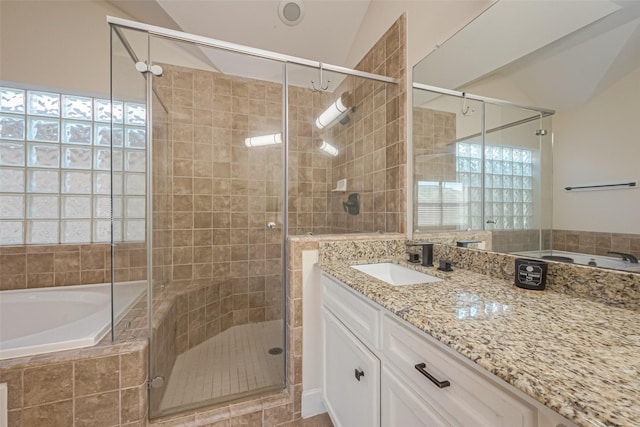 bathroom featuring lofted ceiling, vanity, and independent shower and bath