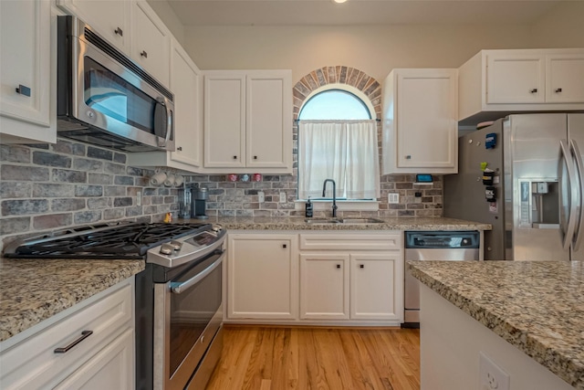 kitchen featuring white cabinetry, sink, light hardwood / wood-style floors, and appliances with stainless steel finishes