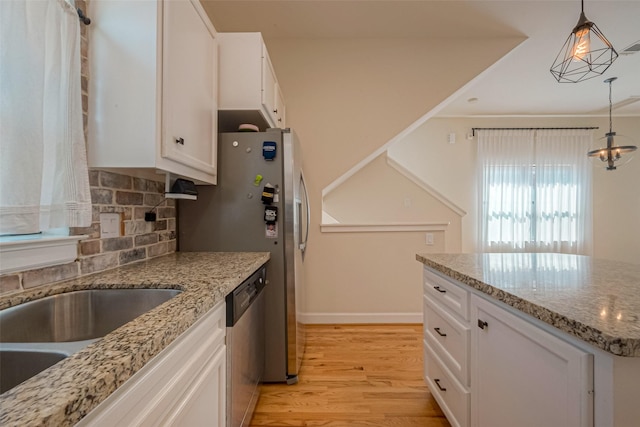 kitchen with white cabinetry, hanging light fixtures, stainless steel appliances, and light wood-type flooring