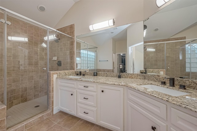 bathroom featuring tile patterned floors, vanity, vaulted ceiling, and a shower with door