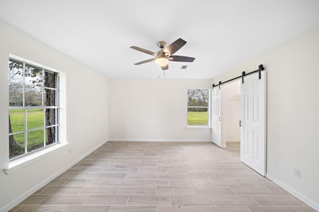 empty room with ceiling fan and a barn door