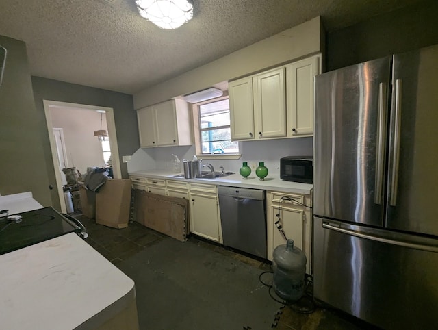 kitchen with appliances with stainless steel finishes, a textured ceiling, white cabinetry, and sink