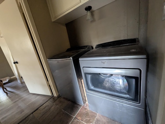 laundry area with cabinets, dark hardwood / wood-style floors, and washing machine and clothes dryer