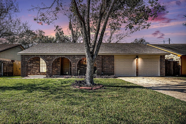 ranch-style home with a garage and a lawn