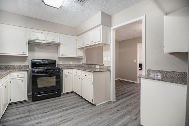 kitchen with white cabinets, dark stone countertops, black range with gas cooktop, and a textured ceiling